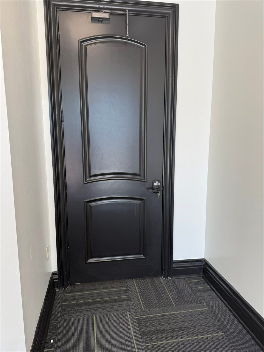 Custom black-framed exam room door at the Audibel clinic in Gretna