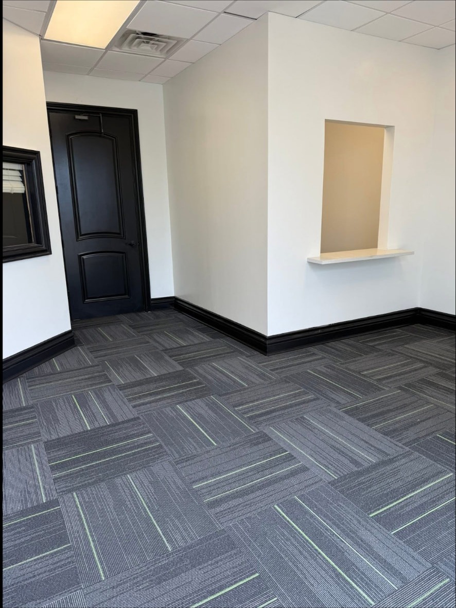 Finished exam room with carpet tile and black trim at the Audibel clinic in Gretna